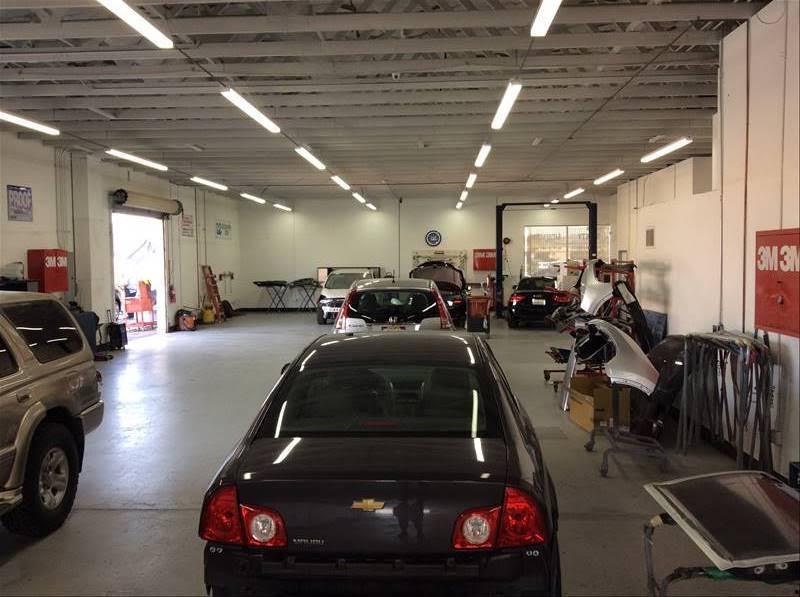 Repair bays with a dark Chevrolet sedan and equipment