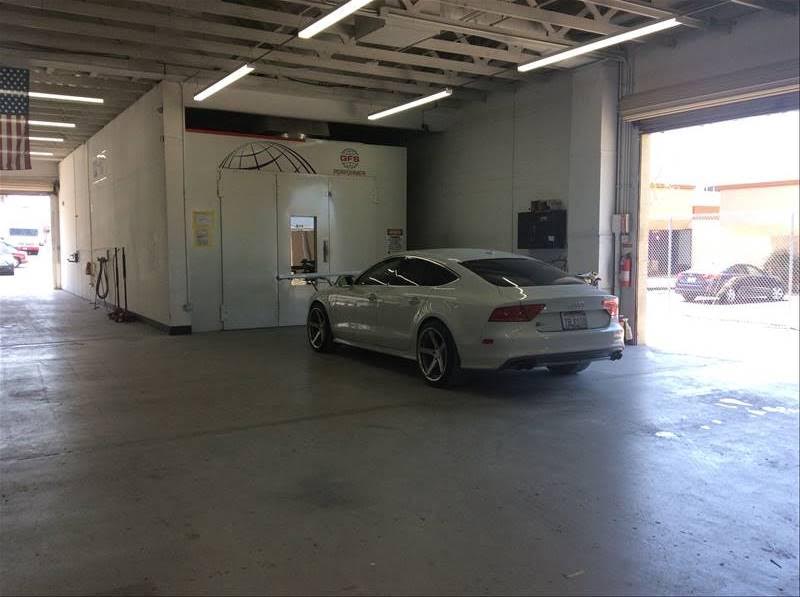 Shop interior with a white Audi near the downdraft paint booth